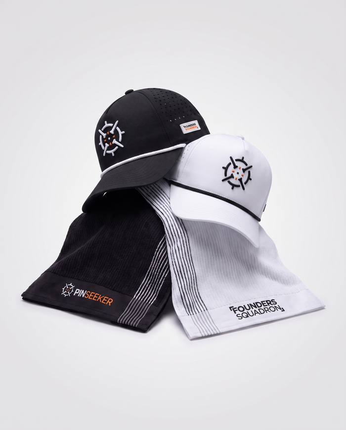 PINSEEKER Founders Squadron caps and caddy towels draped together in Blackout and Whiteout