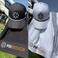PINSEEKER Founders Squadron cap and caddy towel in Blackout and Whiteout, on golf bags in sunshine