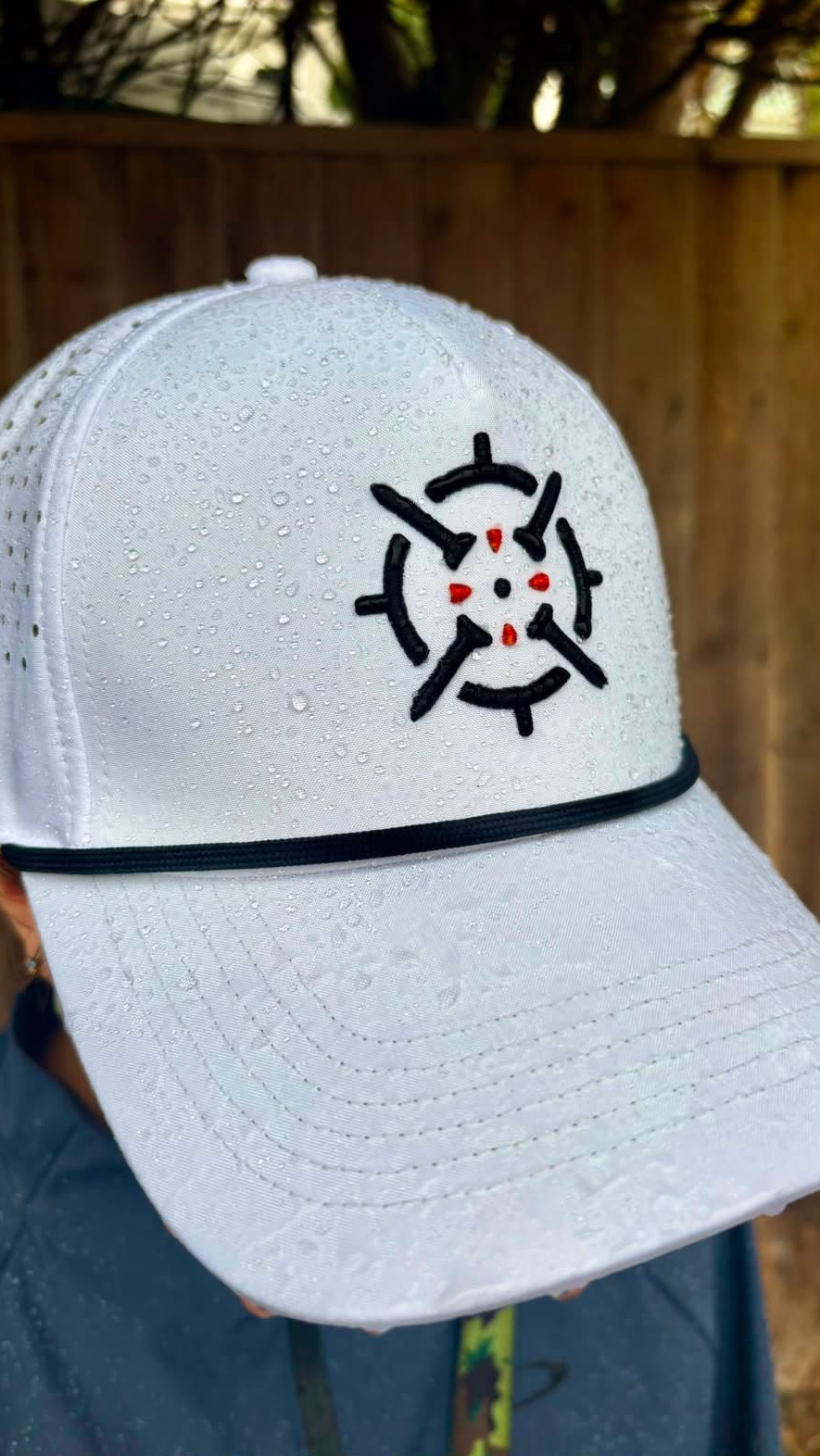 PINSEEKER Performance Golf Cap in Whiteout worn in the rain, water beading on the fabric
